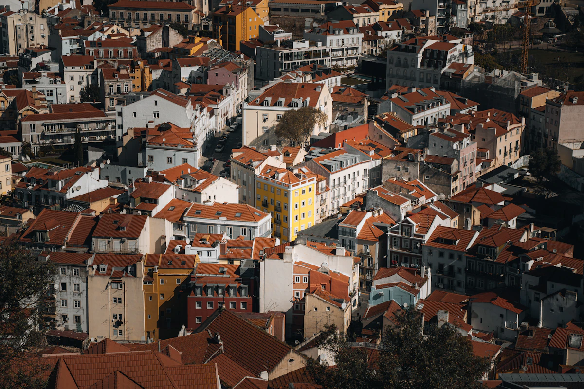Colorful buildings and terracotta rooftops of Lisbon, Portugal with the Tagus River in the distance