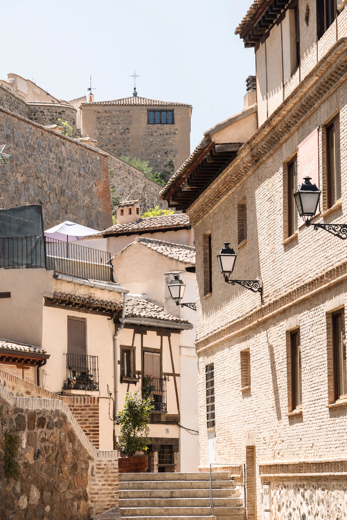 A narrow medieval street in Toledo, Spain with historic stone buildings
