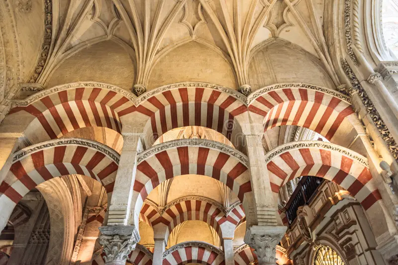 Rows of double-tiered arches stretching into the distance inside the Mezquita of Cordoba